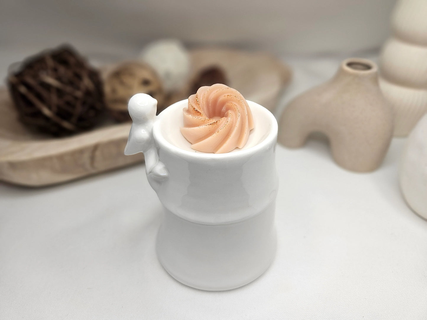 Fondant parfumé à l’ambre en spirale, vu de 3/4 dans un brûle-parfum – cire végétale artisanale et parfum chaud