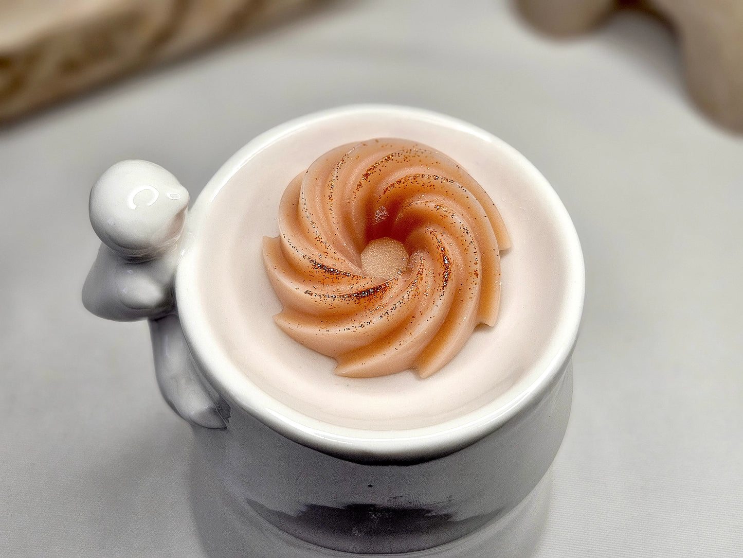 Vue du dessus d’un fondant parfumé à l’ambre en spirale – cire naturelle, fabrication artisanale, notes boisées