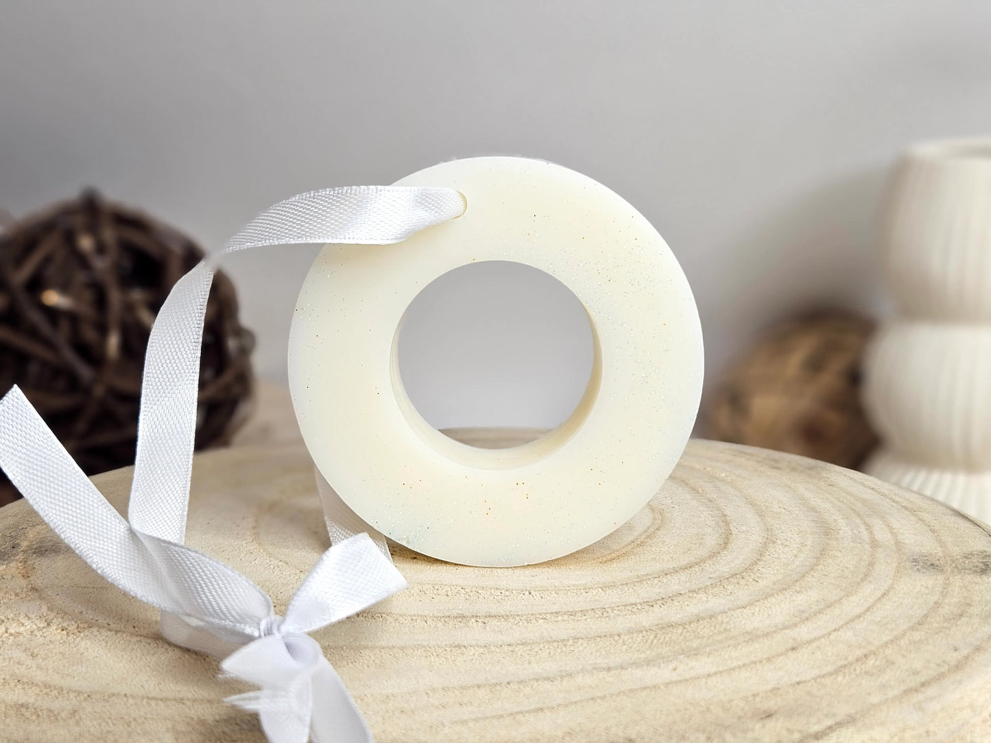 Suspension Parfumée Fleur de Coton, vue de face. Un cercle orné d'un ruban, conçu pour être suspendu dans des espaces clos tels que penderies, placards ou tiroirs, diffusant une fragrance fraîche et douce de fleur de coton. Parfait pour ajouter une atmosphère apaisante et légère à votre intérieur. | La P'tite Mèche | Laptitemeche.com