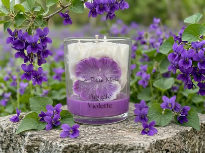 Ambiance douce et poudrée avec la bougie gourmande Violette sur un support en pierre.