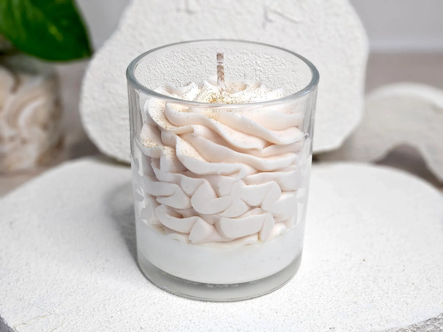 Vue arrière de la bougie Ambre montrant la texture onctueuse de la chantilly de cire et le contenant en verre élégant.