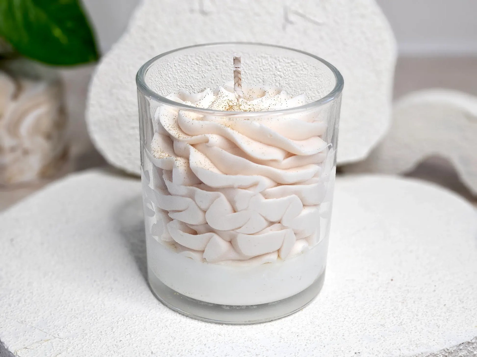 Vue arrière de la bougie Ambre montrant la texture onctueuse de la chantilly de cire et le contenant en verre élégant.