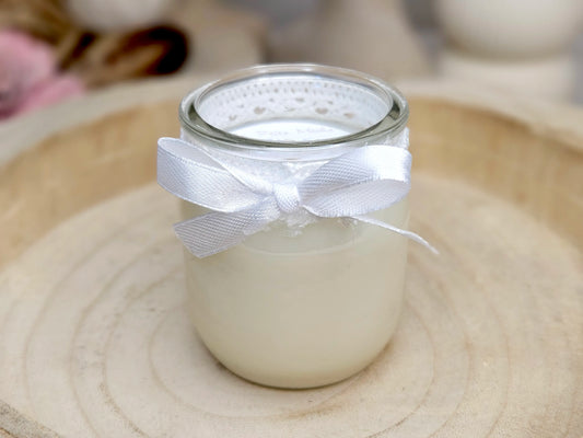 Bougie parfumée artisanale au Lait de Riz dans un pot en verre blanc décoré d'une dentelle et d'un ruban en satin blanc.