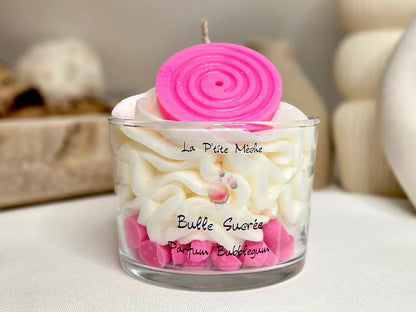 Grande bougie gourmande 190g parfum BubbleGum, vue de face montrant l'étiquette et le dôme de chantilly rose bonbon avec décor pop.