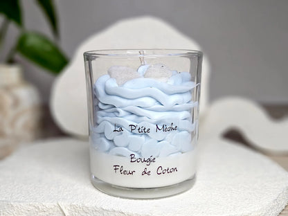 Grande bougie gourmande Fleur de Coton 190g avec dôme de chantilly bleu ciel et décors pailletés, parfum de Grasse linge frais.