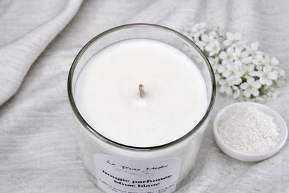 Vue de dessus d'une bougie naturelle au Musc blanc avec mèche en coton, cire blanche fondue dans pot en verre sur fond tissu