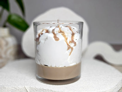 Vue arrière de la bougie madeleine montrant la couche de cire ambrée et la chantilly généreuse façon gâteau.