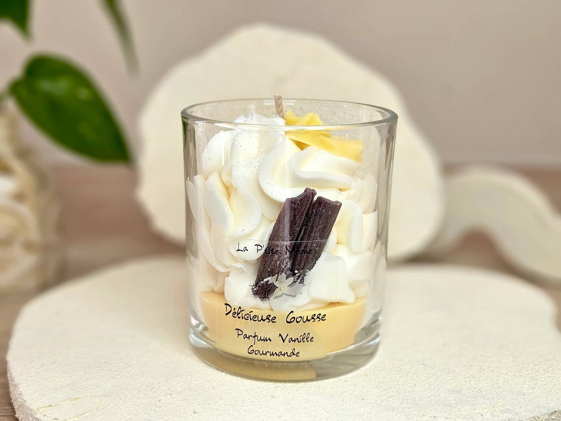 Grande bougie 190g parfum Vanille, vue de face avec étiquette Délicieuse Gourmande, décorée de bâtons de vanille  et fleur jaune en cire.