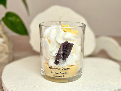 Grande bougie 190g parfum Vanille, vue de face avec étiquette Délicieuse Gourmande, décorée de bâtons de vanille  et fleur jaune en cire.