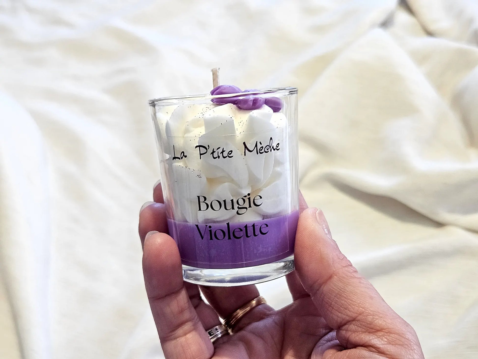 Petite bougie Violette tenue en main, idée cadeau artisanat français éco-responsable.
