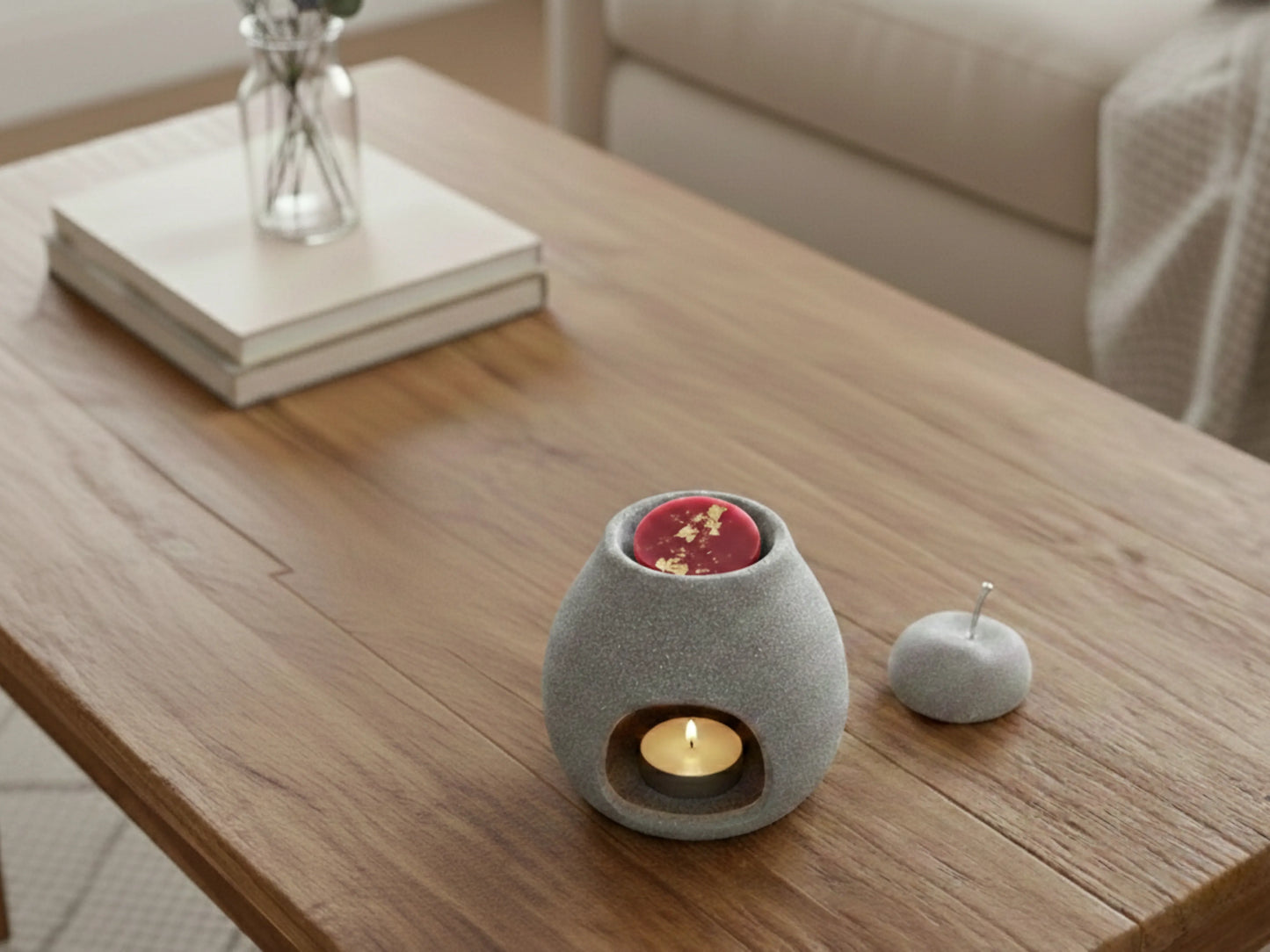 Brûleur de parfum allumé sur une table en bois clair, diffusant une odeur de fraise et de rhubarbe fraîche dans une pièce lumineuse.