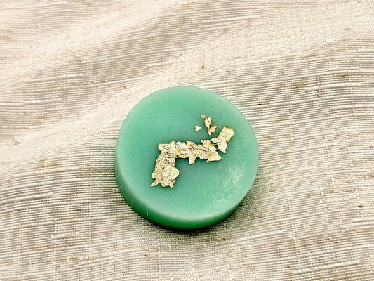 Palet fondant parfumé Menthe et Basilic, couleur vert d'eau avec dorure à la feuille d'or, sur fond de lin naturel.
