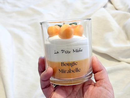 Grande bougie Mirabelle 190g tenue en main pour apprécier le volume et le poids du format gourmand.