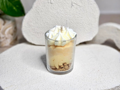 Petite bougie artisanale vue de dos, mettant en avant le travail des couches de couleur jaune et blanc crème.