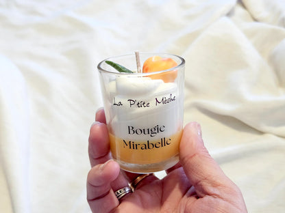 Petite bougie Mirabelle tenue en main, idée cadeau originale et artisanale fabriquée en France.