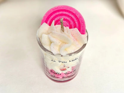Focus sur la mèche coton et la texture aérienne d'une petite bougie parfumée aux notes de confiserie d'enfance.