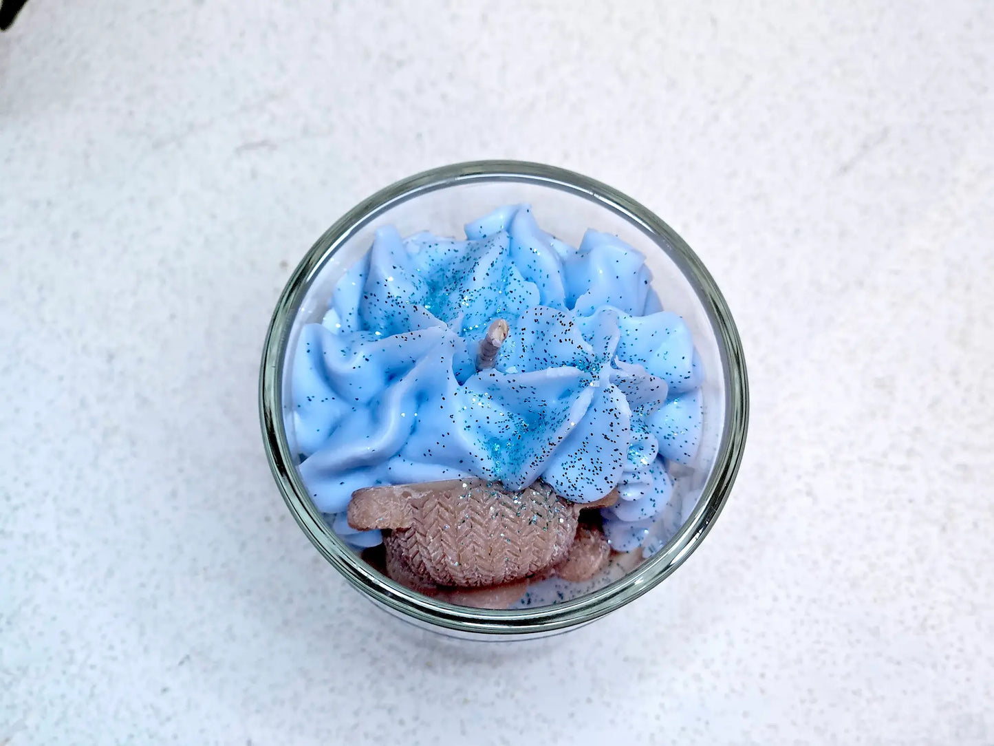 Focus sur la mèche coton et la texture aérienne d'une petite bougie parfumée aux notes réconfortantes d'adoucissant floral.