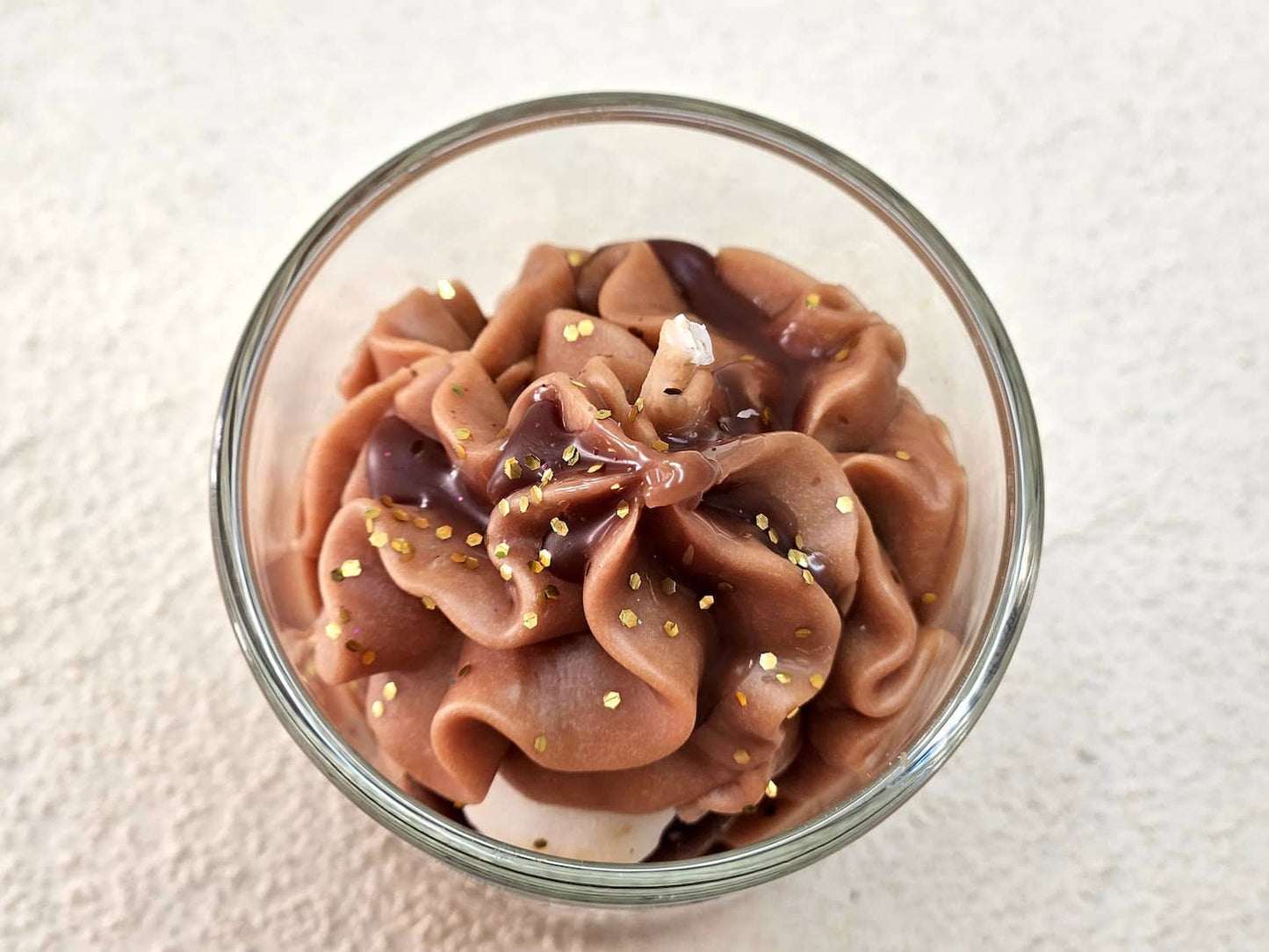 Focus sur la mèche coton et les détails de la chantilly chocolat de **ma** petite bougie parfumée au praliné de Grasse.